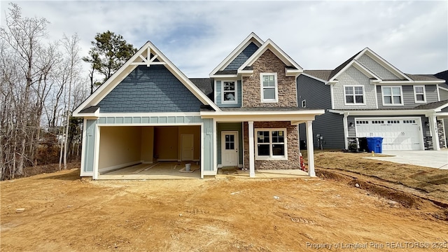 craftsman inspired home with stone siding, board and batten siding, and driveway