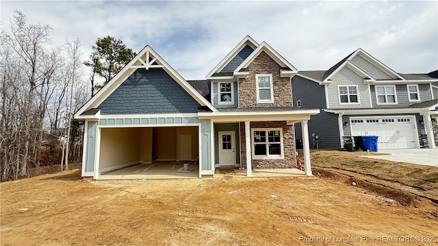 craftsman-style home with a garage, stone siding, board and batten siding, and driveway