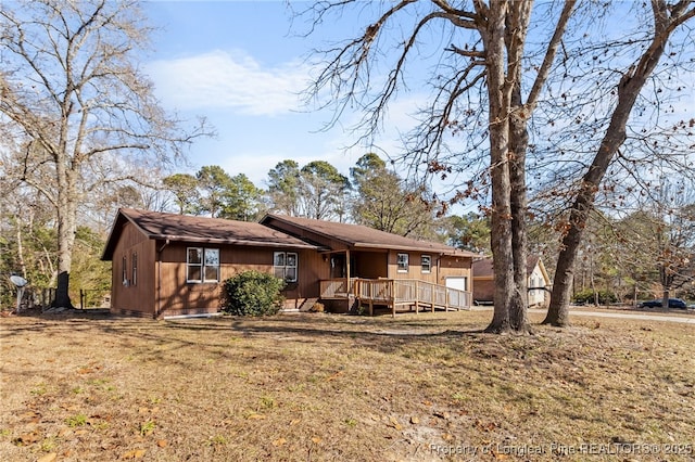 rear view of house featuring a lawn and a deck