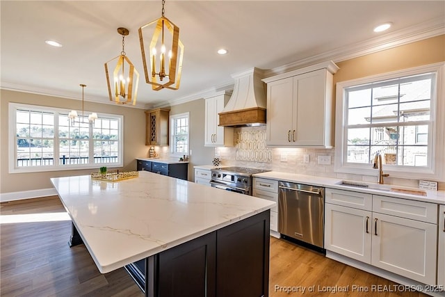 kitchen featuring premium range hood, a kitchen island, pendant lighting, white cabinets, and stainless steel appliances