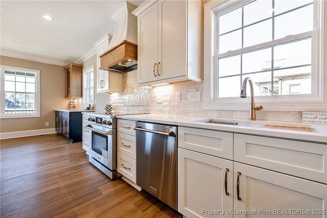 kitchen featuring sink, crown molding, white cabinetry, stainless steel appliances, and decorative backsplash