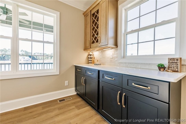 bar featuring decorative backsplash and light hardwood / wood-style flooring