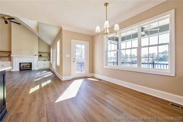 interior space with crown molding, lofted ceiling, ceiling fan with notable chandelier, and light hardwood / wood-style flooring