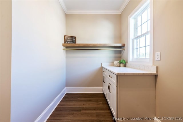 laundry area featuring dark hardwood / wood-style flooring and ornamental molding