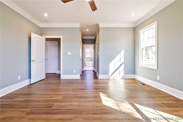 unfurnished room with crown molding, plenty of natural light, hardwood / wood-style floors, and ceiling fan