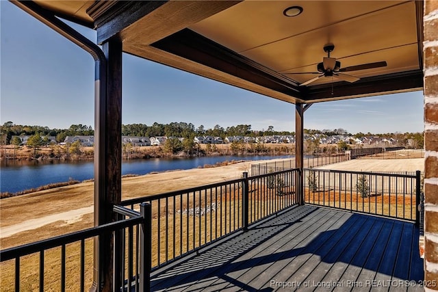 wooden terrace with a water view and ceiling fan