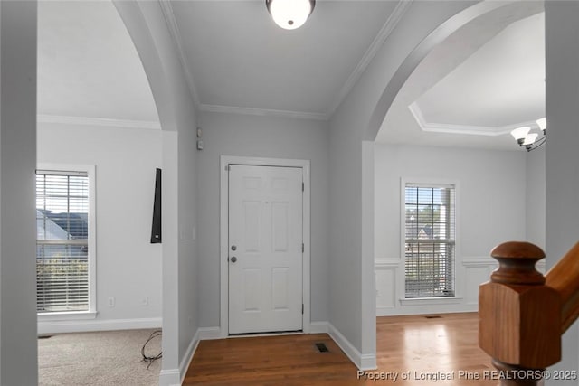 entrance foyer with crown molding and wood-type flooring