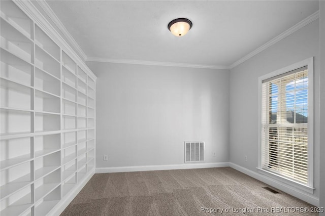 empty room featuring ornamental molding and carpet