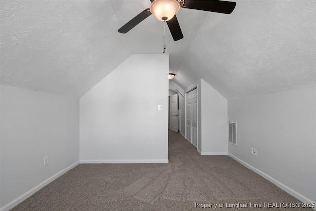 bonus room featuring ceiling fan, vaulted ceiling, a textured ceiling, and carpet