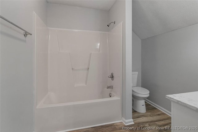 full bathroom featuring hardwood / wood-style flooring, vanity, bathtub / shower combination, and toilet