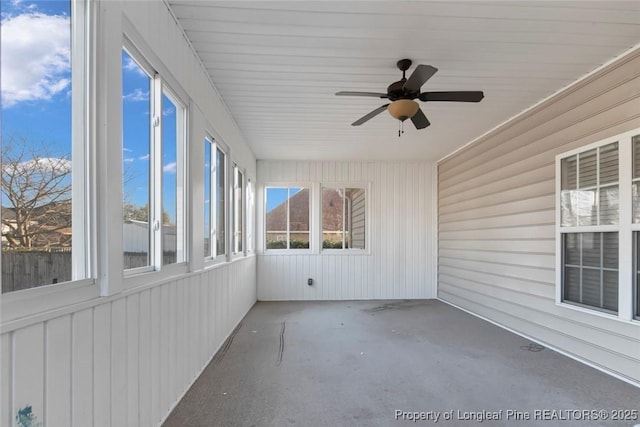 unfurnished sunroom with ceiling fan