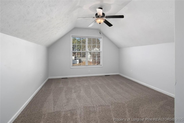 bonus room with ceiling fan, vaulted ceiling, a textured ceiling, and carpet flooring