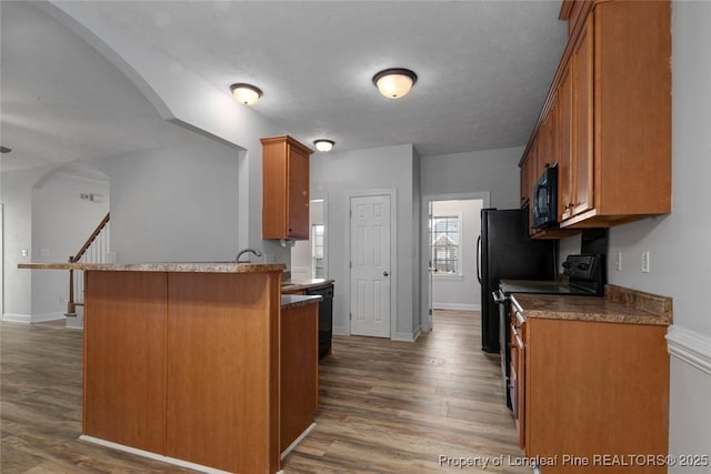 kitchen with range with electric cooktop, dark hardwood / wood-style floors, and kitchen peninsula