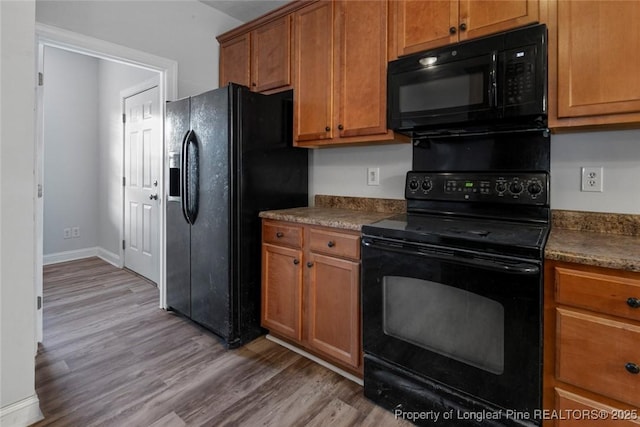 kitchen with light wood-type flooring and black appliances