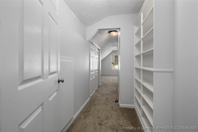 spacious closet with carpet flooring and vaulted ceiling