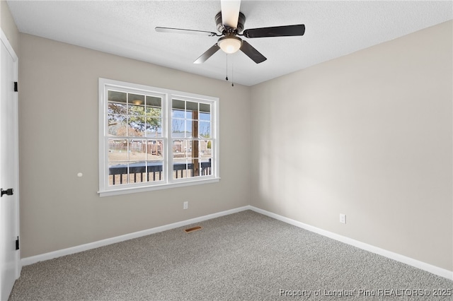 carpeted spare room featuring a textured ceiling and ceiling fan