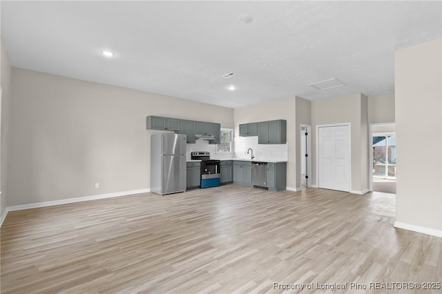 unfurnished living room with sink and light hardwood / wood-style floors