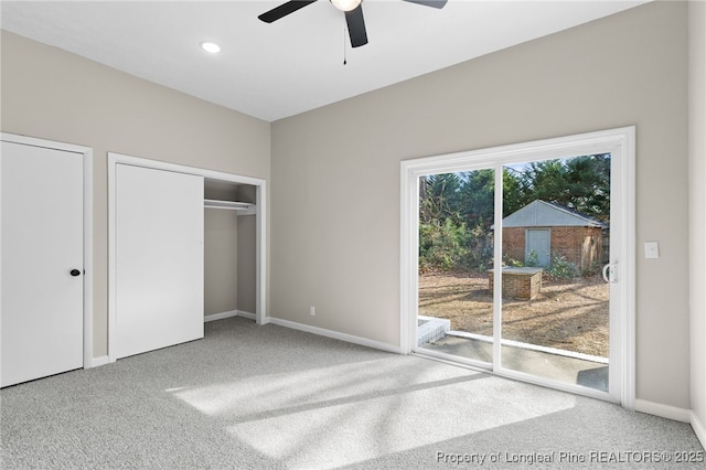 unfurnished bedroom featuring multiple closets, carpet floors, access to outside, and ceiling fan