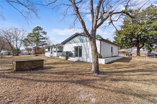 exterior space featuring a sunroom and a lawn