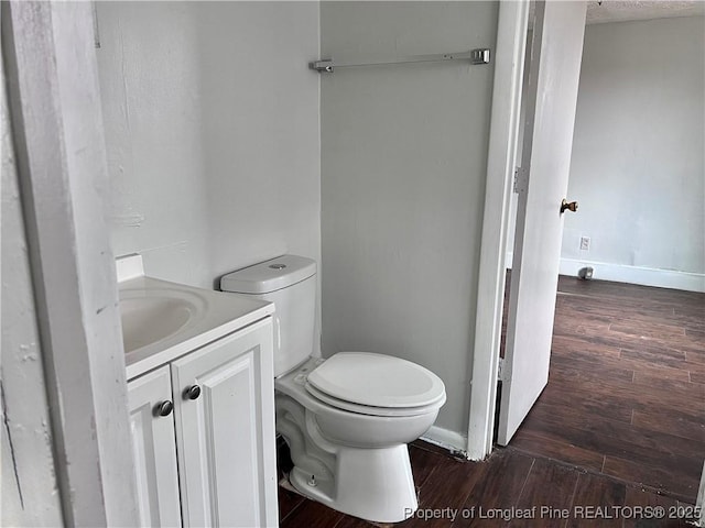 bathroom featuring vanity, hardwood / wood-style floors, and toilet