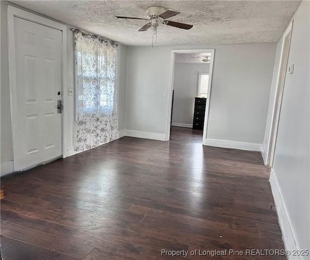 interior space featuring ceiling fan, a textured ceiling, and dark hardwood / wood-style flooring