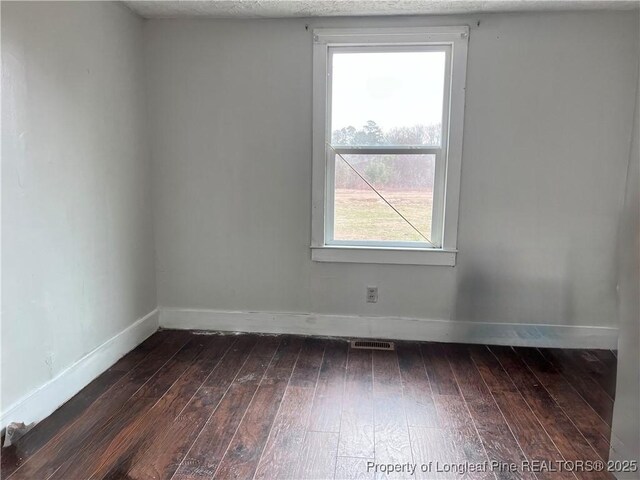 empty room featuring dark hardwood / wood-style flooring