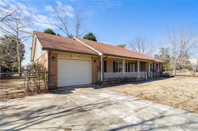 ranch-style home with driveway, an attached garage, covered porch, fence, and brick siding