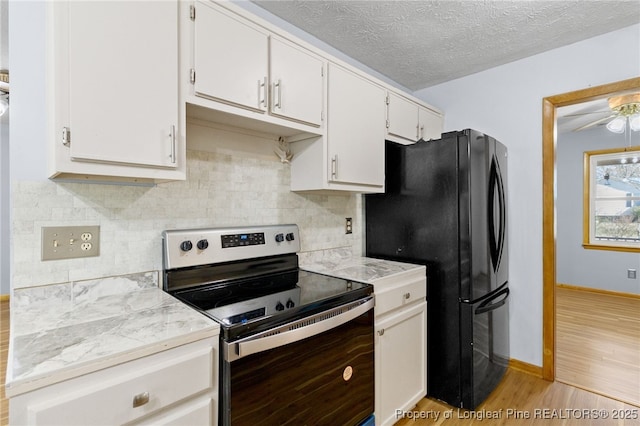 kitchen featuring light wood-type flooring, stainless steel range with electric stovetop, white cabinetry, and light countertops