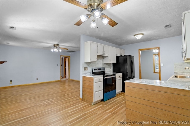 kitchen with electric range, a sink, visible vents, white cabinetry, and light countertops