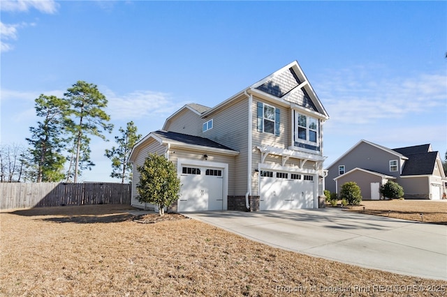 craftsman-style house featuring driveway, a garage, and fence