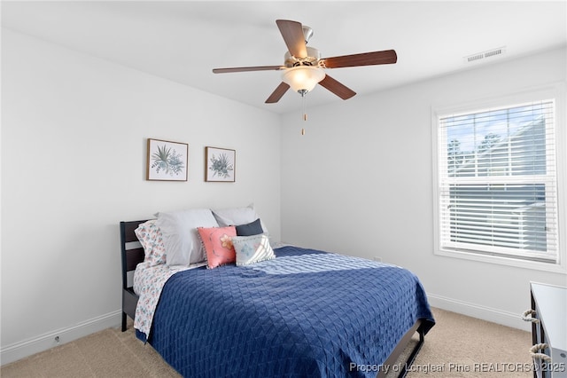 bedroom featuring baseboards, visible vents, ceiling fan, and light colored carpet