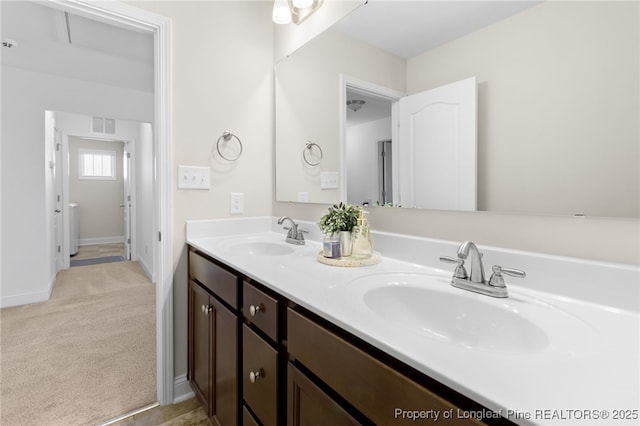 bathroom featuring visible vents, a sink, baseboards, and double vanity