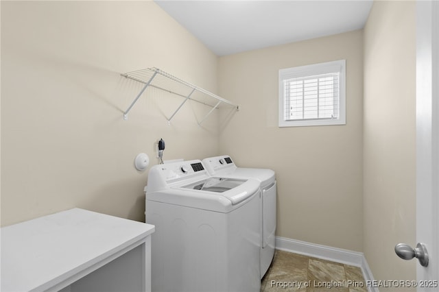 laundry room featuring laundry area, washing machine and dryer, and baseboards