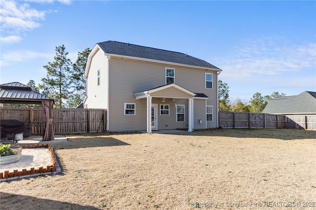 back of house with a fenced backyard, a patio, and a gazebo