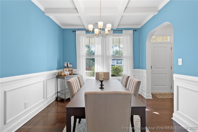 dining space featuring coffered ceiling, dark wood-type flooring, a notable chandelier, and beamed ceiling