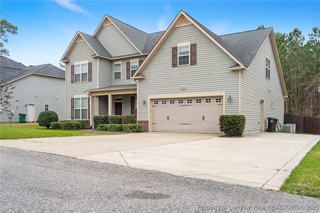 view of front of home featuring brick siding, fence, concrete driveway, central AC, and a garage