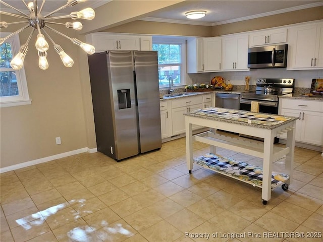 kitchen with light stone countertops, a sink, stainless steel appliances, crown molding, and a chandelier