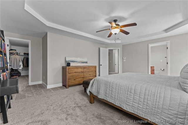 183 Ganton Dr, Raeford, NC 28376 - bedroom with carpet, baseboards, a tray ceiling, ceiling fan, and a walk in closet