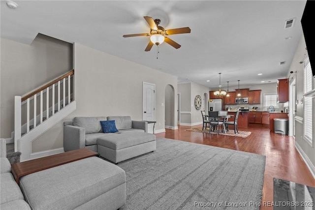 183 Ganton Dr, Raeford, NC 28376 - living area with visible vents, dark wood-style floors, arched walkways, ceiling fan, and stairs