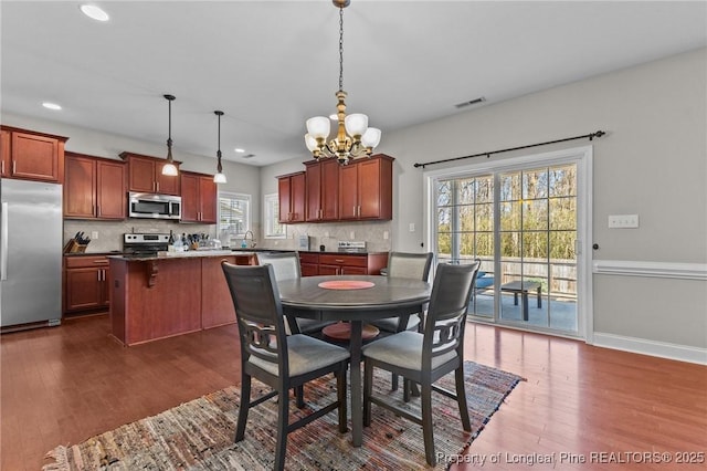 183 Ganton Dr, Raeford, NC 28376 - dining area featuring dark wood finished floors, baseboards, visible vents, and a chandelier