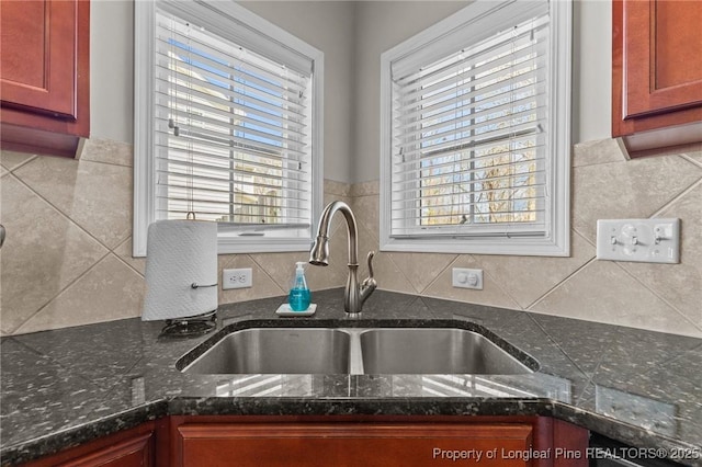 183 Ganton Dr, Raeford, NC 28376 - kitchen with a sink, dark brown cabinets, a wealth of natural light, and dark stone countertops