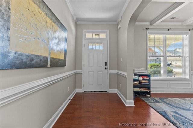 entrance foyer with wood finished floors, baseboards, visible vents, arched walkways, and crown molding