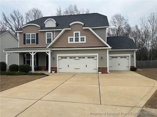 craftsman-style house featuring a porch, driveway, an attached garage, and roof with shingles