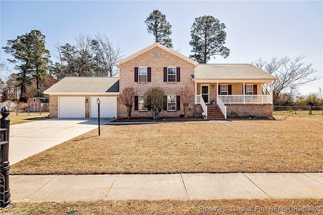 tri-level home featuring a porch, an attached garage, a front yard, and concrete driveway