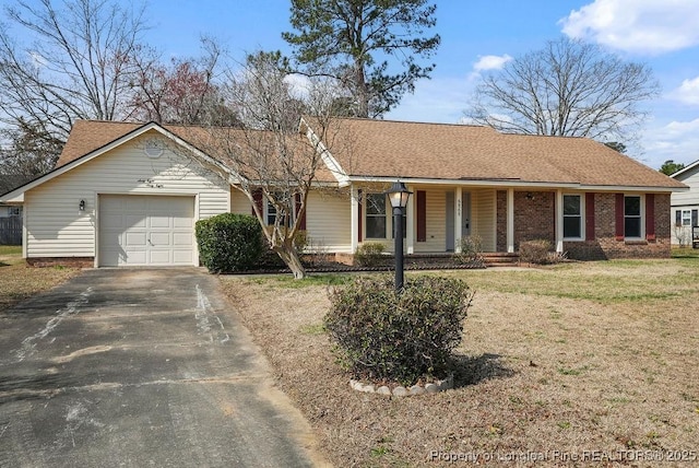 single story home featuring aphalt driveway, brick siding, a garage, and a front yard