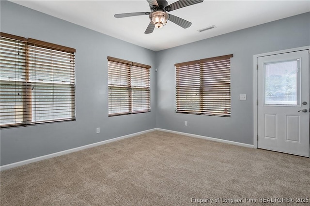 unfurnished room featuring ceiling fan, baseboards, visible vents, and light colored carpet