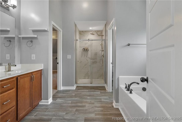 bathroom with a bath, wood finished floors, vanity, and a shower stall