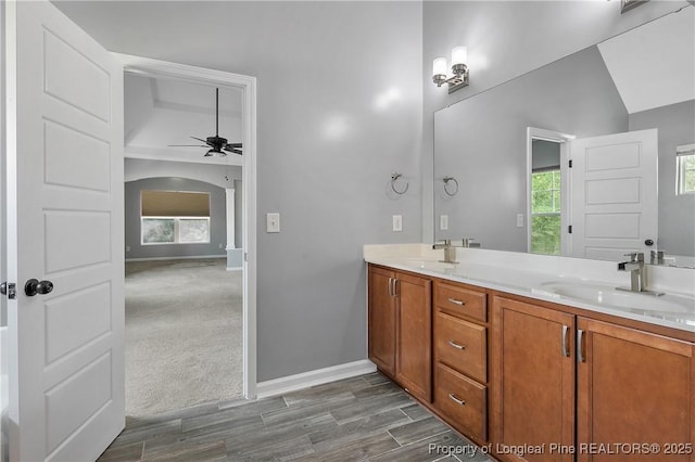 bathroom with double vanity, wood finished floors, ceiling fan, and a sink