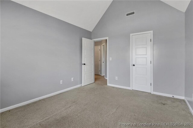 unfurnished bedroom featuring visible vents, baseboards, high vaulted ceiling, and carpet flooring