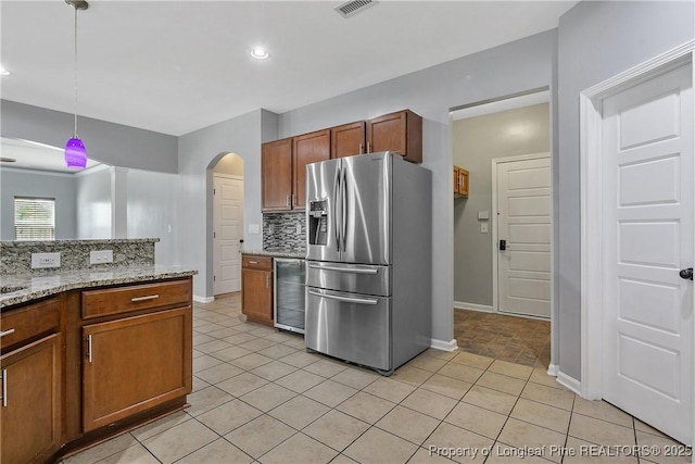 kitchen with decorative backsplash, beverage cooler, stainless steel fridge, pendant lighting, and baseboards